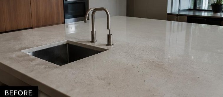 Kitchen benchtop and sink before cleaning — stone dulled and marked with built-up residue
